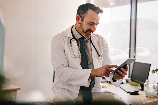 Doctor using digital tablet at his clinic Health care professional